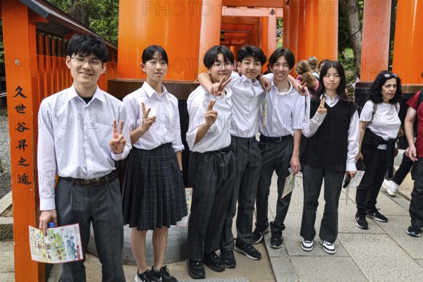 Students pose in front of torii at Fushimi Inari Shrine in Kyoto, Fushimi, Kyoto, Japan