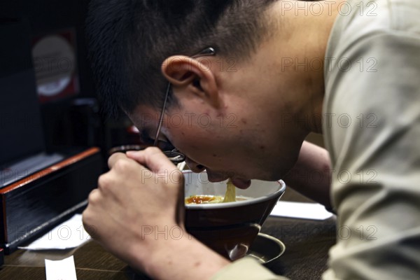 Guest at Ramen Restaurant in Higashiyama devotedly enjoys his meal, Kyoto, Higashiyama, Japan