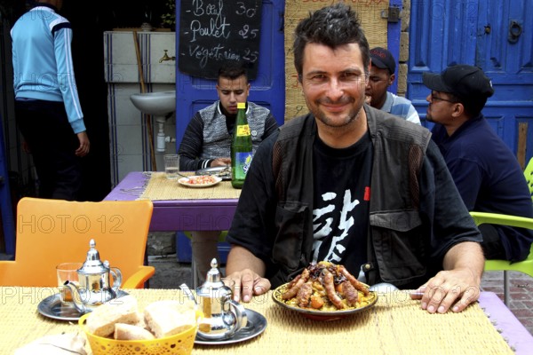 Man enjoying couscous in an atmospheric restaurant in the old town, Essaouira, Morocco