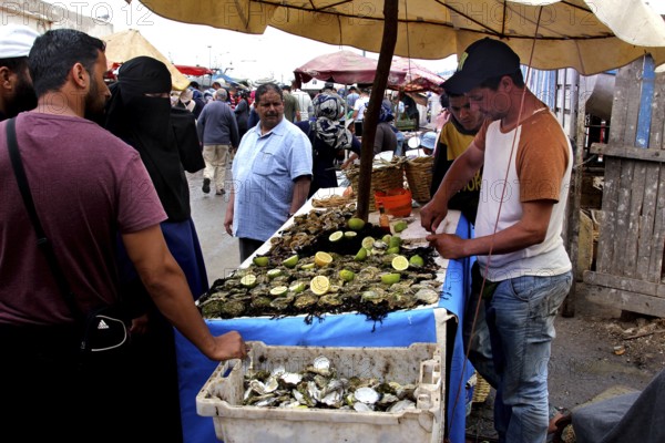 A man sells seafood at a market stall in Essaouira, Essaouira, Morocco