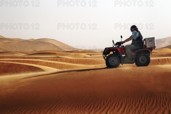 Quad driver navigates the impressive sand dunes of Erg Chebbi, Erg Chebbi, Morocco
