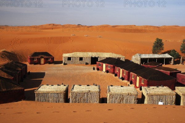 Desert camp in Erg Chebbi with tents and huts in a sandy desert landscape, Erg Chebbi, Morocco