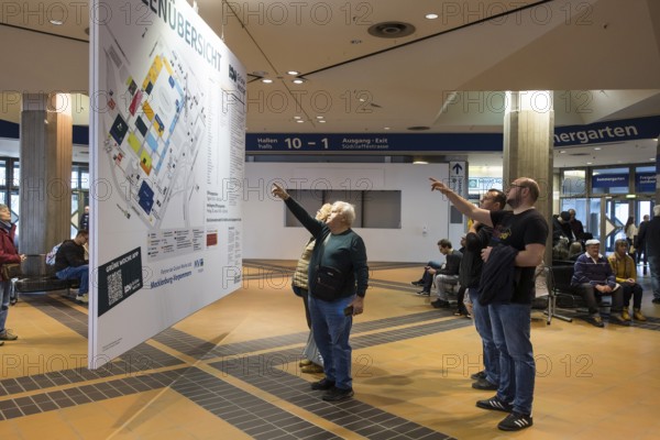 Visitors point to a map of the Green Week at the exhibition center in Berlin on 16.01.2026. The Agricultural and Food Industry Fair will take place from January 16-25, 2026