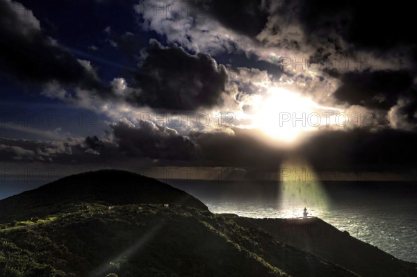 Sunset over the ocean at Cape Reinga with rolling clouds and rays of light, Cape Reinga, Northland, New Zealand