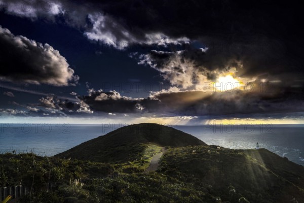 Sunset over the hills near Cape Reinga with rays of light through clouds, zero