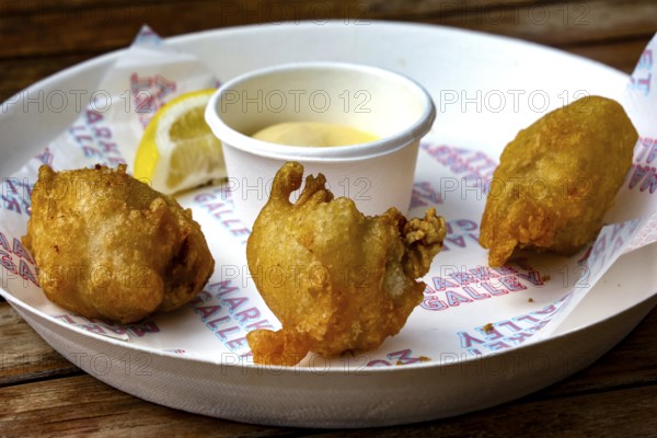 Fried oysters on a plate with lemon and dip at Wynard Quarter Fish Market, Auckland, North Island, New Zealand