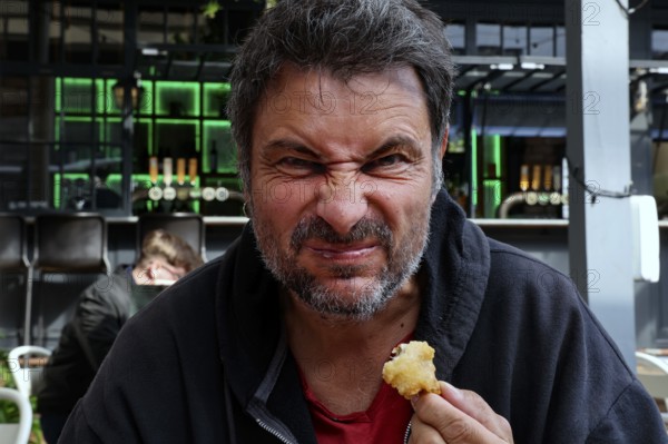Man tries fried oysters at Wynard Quarter fish market in Auckland, Auckland, North Island, New Zealand