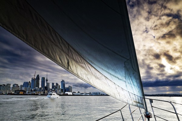 Sailing trip in dramatic atmosphere with views of Auckland City in the evening, Auckland, region, New Zealand