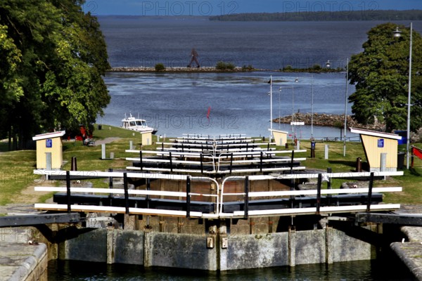 Lock system in the Göta Canal near mountain, with water and surrounding landscape under wide sky, mountain, Sweden