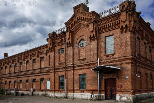 Historic brick prison with lattice windows under cloudy sky, Liepaja, Karosta, Latvia