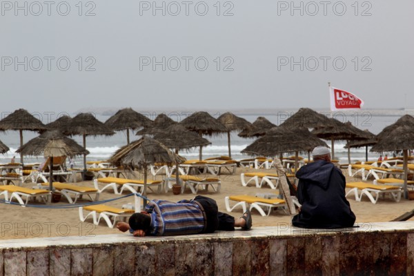 Umbrellas and sun loungers line Agadir beach, where gentle waves break, Agadir, Morocco