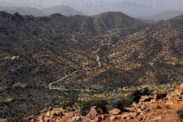 Wasteland landscape with a winding road and barren vegetation in the mountains, Anergui, zero, Morocco