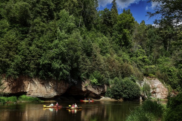 Lined river in Gauja National Park with canoe and steep rocks in the background, Gauja National Park, Latvia