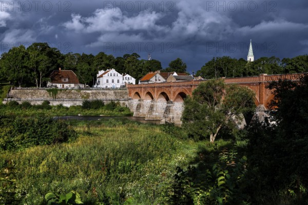 Historic brick bridge across the Venta near Kuldiga, surrounded by lush vegetation, Kuldiga, Courland, Latvia