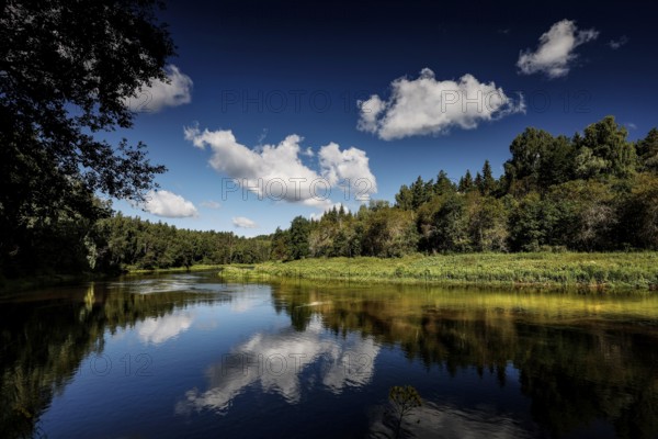 Calm river in Gauja National Park with beautiful reflection of clouds, Ligatne, Latvia