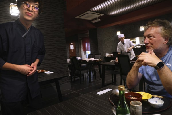 Guest is served by a waiter at a kaiseki restaurant, Kyoto, Okazaki, Japan