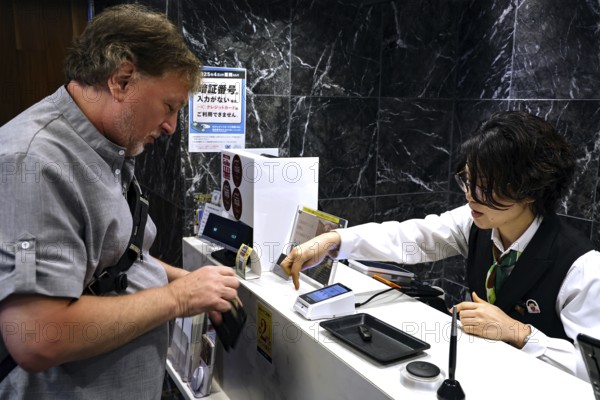 Man pays at the cash register in a restaurant, Kobe, Japan
