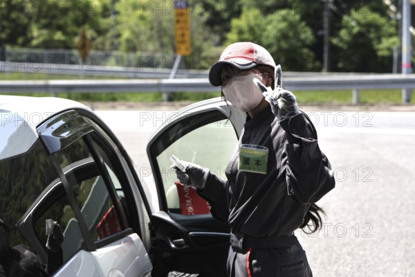 A gas station attendant in Kyoto interacts in a friendly manner with a customer, Kyoto, Kyoto, Japan