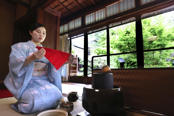 Tea master with red towels at tea ceremony, looking outside, Kyoto, Higashiyama, Japan
