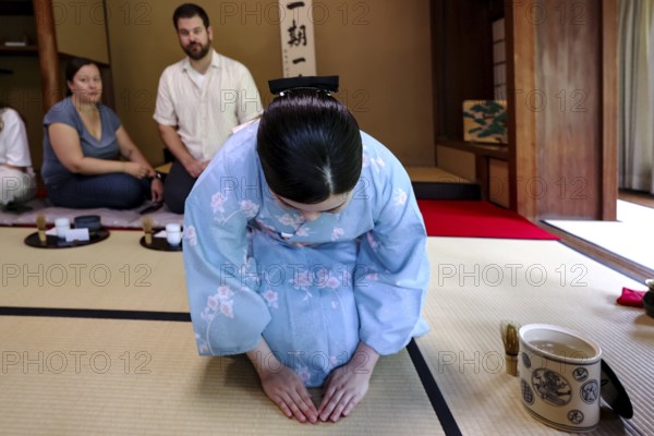 Tea master bows during tea ceremony, guests watching, Kyoto, Higashiyama, Japan