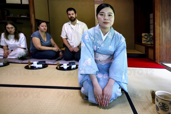 Tea master in blue kimono at tea ceremony, spectator in the background, Kyoto, Higashiyama, Japan