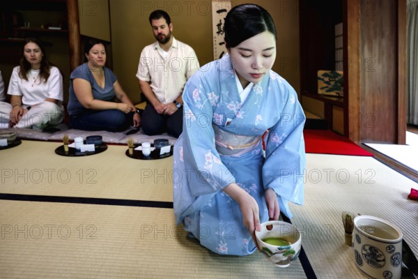Tea master during a tea ceremony with guests, serving traditional green tea, Kyoto, Higashiyama, Japan