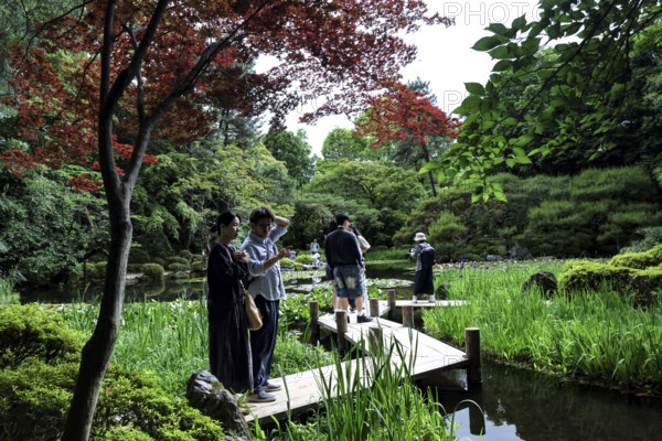 Visitors on the zigzag bridge in Heian-jingu Garden, Kyoto, Kyoto, Japan