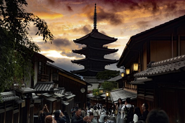 Yasaka Pagoda at sunset, framed by traditional architecture and a dramatic sky, Kyoto, Higashiyama, Japan