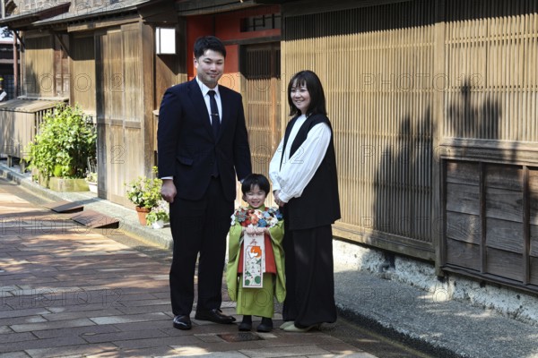 Family with child posing on the street in Nishi Chaya tea house district in Kanazawa, Kanazawa, Ishikawa, Japan