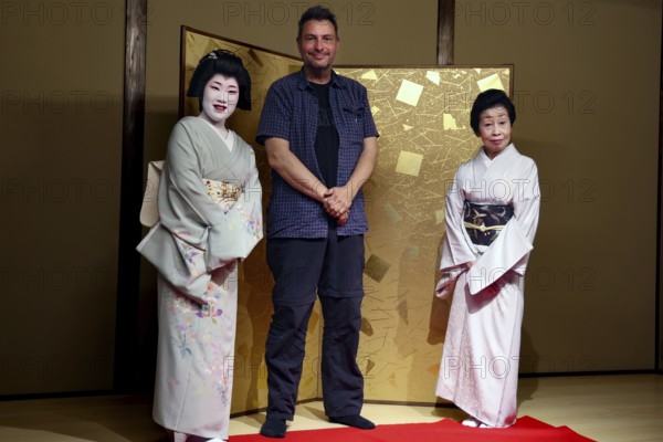 Two geishas and a man pose in the Nishi Chaya tea house district in Kanazawa, Kanazawa, Ishikawa, Japan