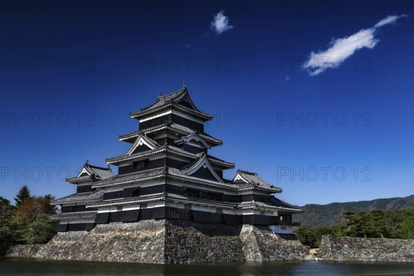 Matsumoto Castle surrounded by water and blue sky, Matsumoto, Nagano, Japan