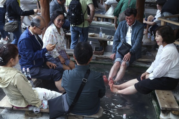 Visitors enjoy a foot bath at Kamado Jigoku in Beppu in a relaxed atmosphere, Beppu, Oita, Japan