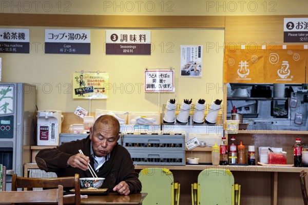 Guest eats ramen at a simple restaurant in Aso, Aso, Japan