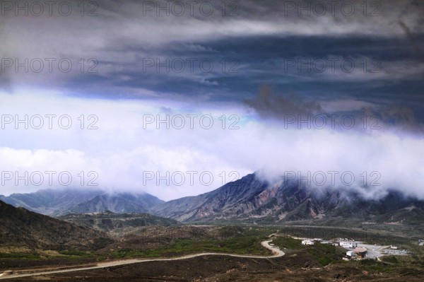 Far-reaching view of mountains and volcanic craters under dramatic cloud formation, Aso, Kumamoto, Japan