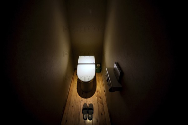 Minimalist toilet in the ryokan with atmospheric lighting