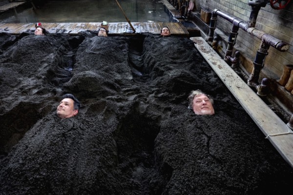 People lie in a sand bath at Takegawara Onsen in Beppu, Beppu, Oita, Japan