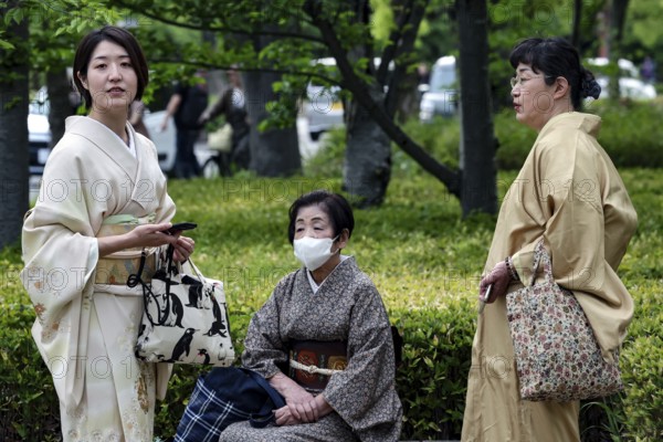 Three woman wearing traditional kimono in the park in Himeji, one wearing a mask, Himeji, Hyogo, Japan