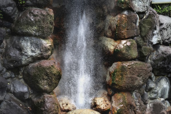 Close-up of steaming geyser surrounded by mossy rocks, Beppu, Oita, Japan