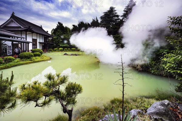 White plumes of steam over the green water of Shiraike Jigoku in Beppu, Beppu, Kyushu, Japan