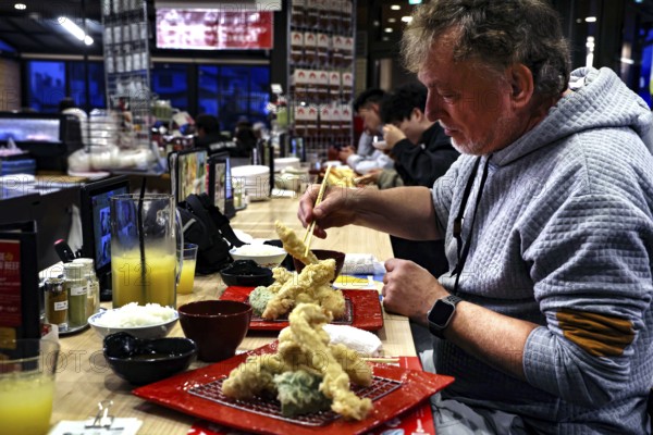 Guest enjoying tempura at the bar at Idaten restaurant in Kawaguchi, Kawaguchi, Japan