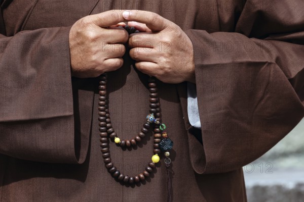 Monk with prayer necklace at Kotokuin Temple in Kamakura, Kamakura, Japan