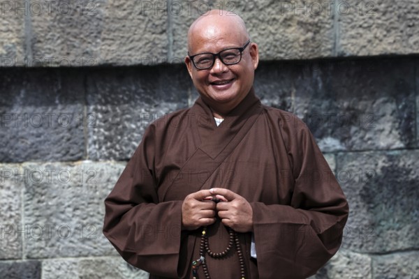 Smiling monk wearing traditional robe at Kotokuin Temple in Kamakura, Kamakura, Japan