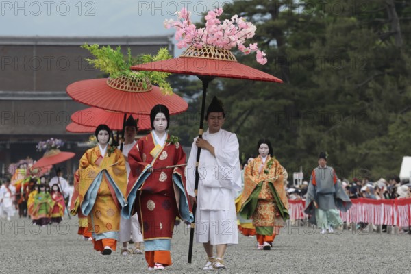 Traditional procession with geishas and red umbrellas during Aoi Matsuri in Kyoto, Kyoto, Japan