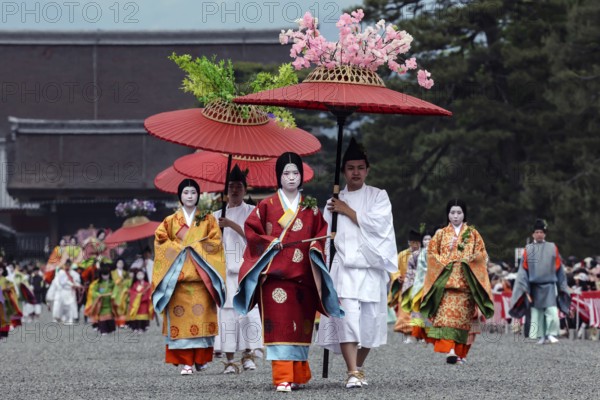 Colourful geisha procession with red umbrellas during Aoi Matsuri in Kyoto, Kyoto, Japan