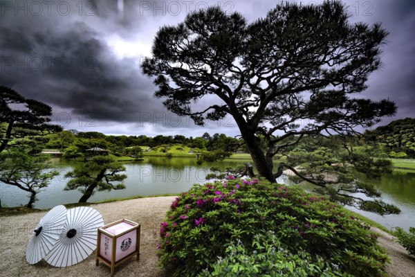 Jardin in Korakuen with a view of the lake and dramatic sunbeams through the clouds, Okayama, Okayama, Japan