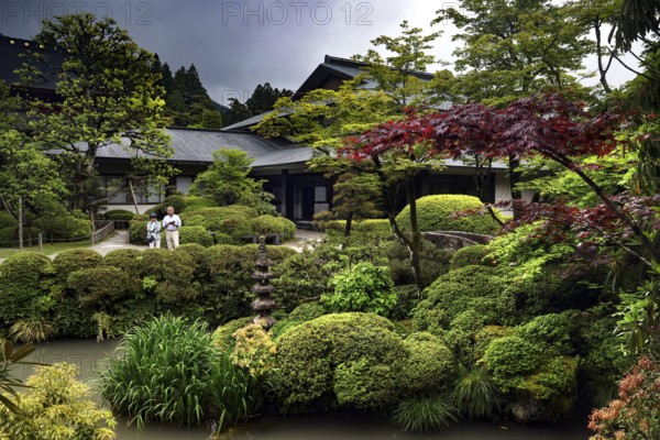 Lush Japanese garden with pagoda and well-kept greenery surrounded by stones, Nikko, Tochigi, Japan