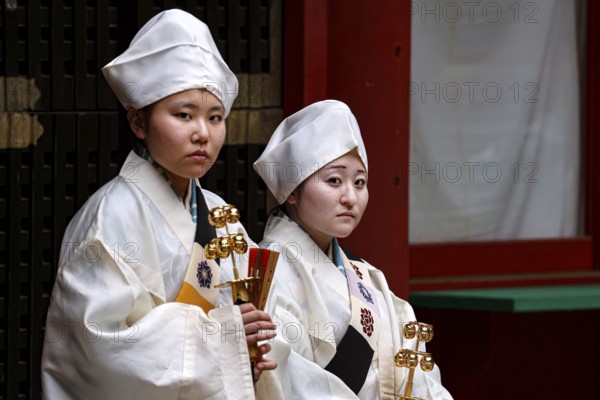 Two female carpenters in traditional dress in the courtyard of Toshogu Shrine, Nikko, Tochigi, Japan
