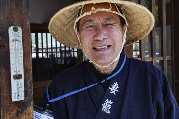 Man wearing traditional clothing wearing straw hat in Tsumago, Tsumago, Japan