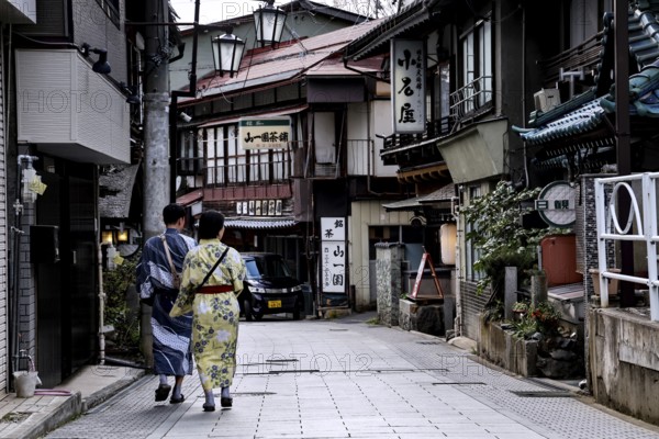 People in Yukata stroll down a traditional street in Yamanouchi, Yamanouchi, Nagano, Japan