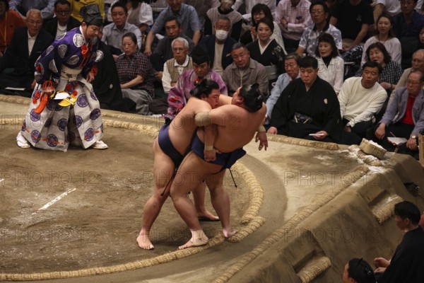Intense sumo ring scene at Ryogoku Kokugikan Hall, Tokyo, Japan